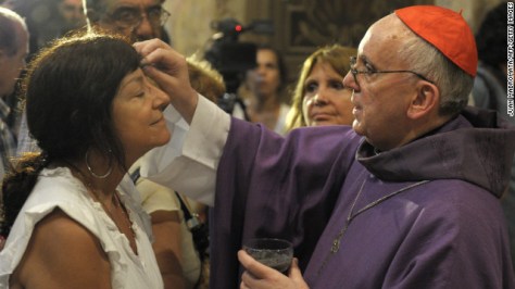 Bergoglio, right, draws the cross on the forehead of a parishioner during a Mass for Ash Wednesday, which begins the 40-day period of abstinence for Christians before the Holy Week and Easter, on February 13 at the Metropolitan Cathedral in Buenos Aires